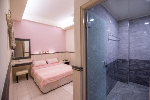 a bedroom with a bed and a glass shower at For you Bed and Breakfast in Magong