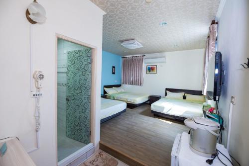 a hotel room with two beds and a shower at For you Bed and Breakfast in Magong