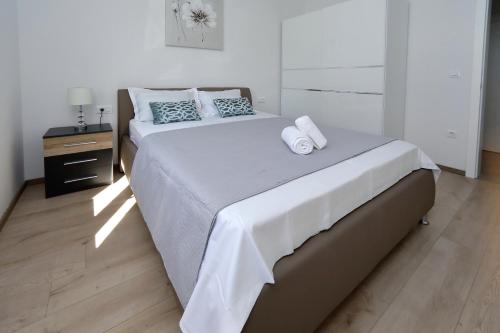 een slaapkamer met een groot bed en 2 handdoeken bij Villa Thalia in Bibinje