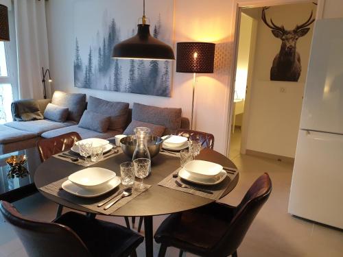 - une table à manger avec des chaises et un canapé dans l'établissement Les Campanules, à Bourg-Saint-Maurice