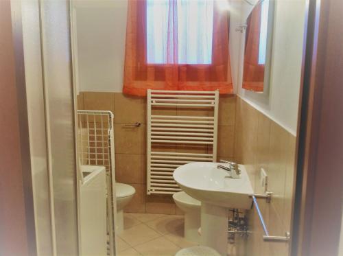 a small bathroom with a toilet and a sink at RESORT VILLAGE AQUA MARINA FAMILY - Daily Rooms Tidying - CocktailsBar- Pet Friendly - with Hypermarket - Delivery Restaurant-Pizzeria - Room Breakfast with supplement - Ultra Fast Wi-Fi - Play Area for children - Olympic Swimming Pool - Parking in Caorle