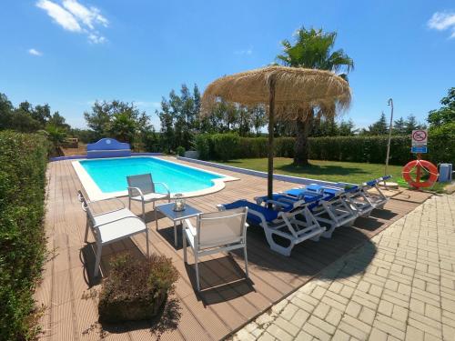 a group of chairs and an umbrella next to a swimming pool at Country House Porto Covo, Monte da Casa Velha in Santiago do Cacém