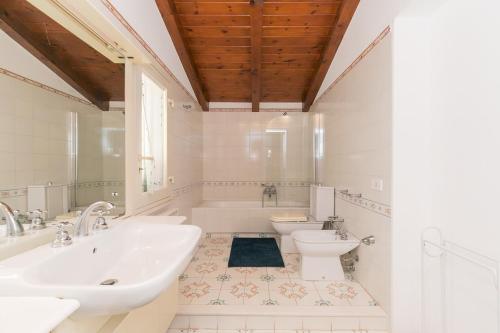 bagno con 2 lavandini, vasca e servizi igienici di Villa Sara Costa Pergola ad Augusta
