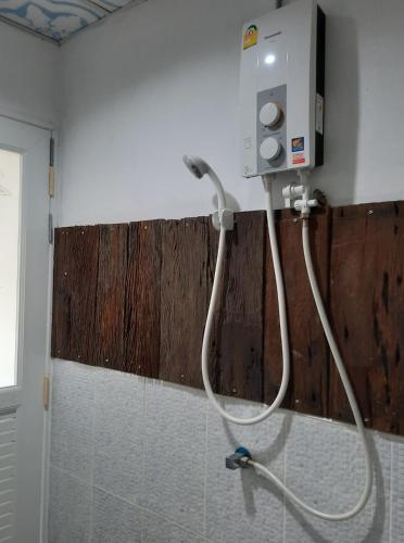 a shower in a bathroom with a hose attached to the wall at Heuan Na Khee in Udon Thani