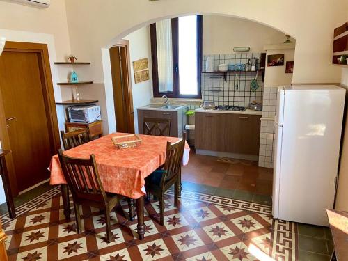 kuchnia ze stołem, krzesłami i lodówką w obiekcie Casa di Marco w mieście Galatina