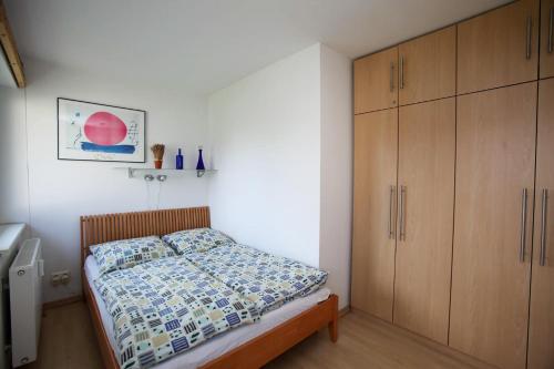 a bedroom with a bed and a wooden cabinet at Fewo Kaiser Am Lindenpark - Free Wifi in Kühlungsborn