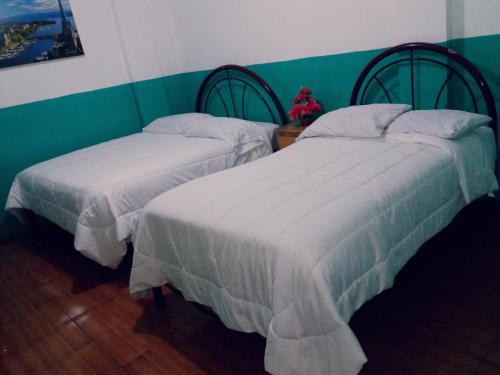 2 nebeneinander sitzende Betten in einem Schlafzimmer in der Unterkunft Nápoles Emperador II in Ambato