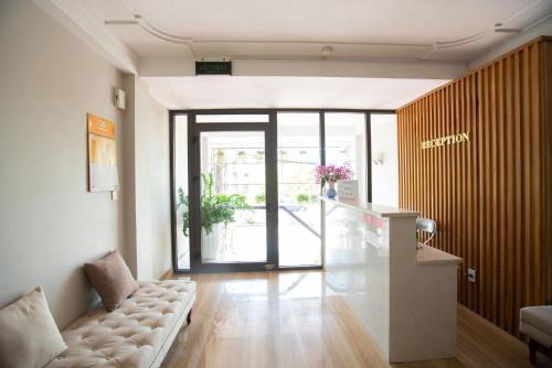 Candy Hotel في ها لونغ: غرفة معيشة مع أريكة وباب مفتوح