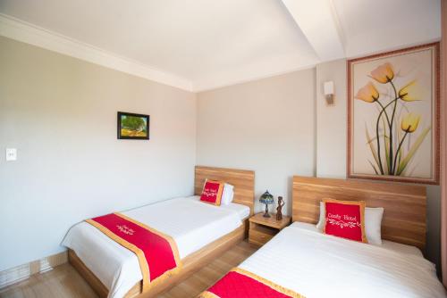 a bedroom with two beds and a painting on the wall at Candy Hotel in Ha Long