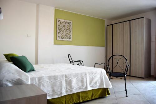 1 dormitorio con 1 cama, mesa y sillas en Residenza Al Castello, en Carloforte