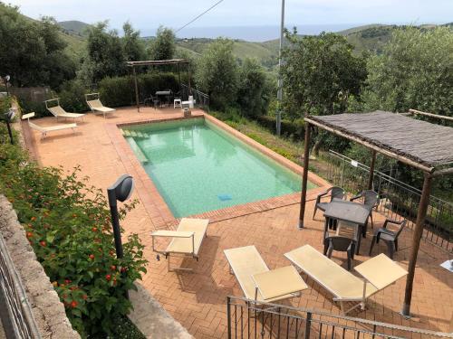 a swimming pool with chairs and a gazebo at Residenza La Mannara in Itri