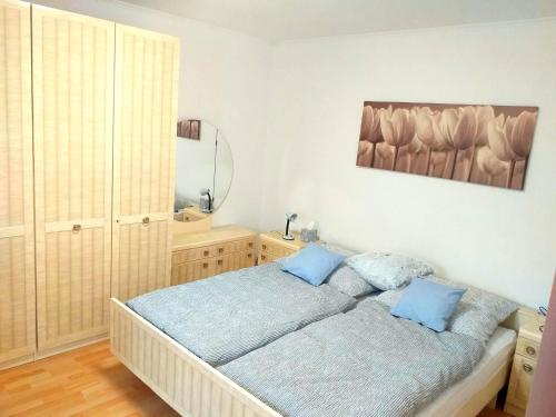 een slaapkamer met een bed met twee blauwe kussens bij Napvirág Vendégház in Keszthely