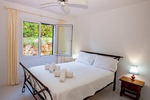 ein Schlafzimmer mit einem Bett mit weißen Laken und einem Fenster in der Unterkunft Villa Cecylia in Es Canutells