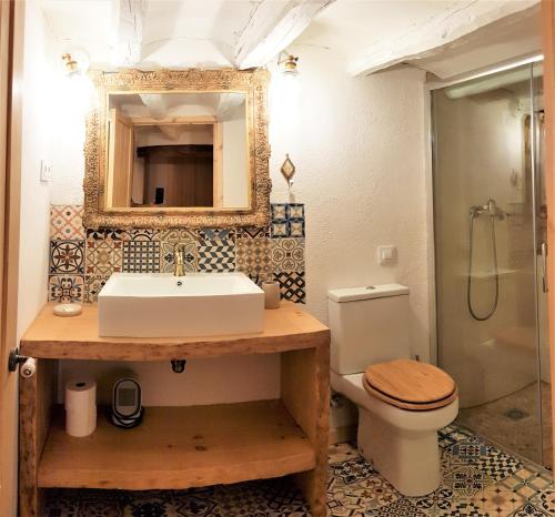 W łazience znajduje się umywalka, toaleta i lustro. w obiekcie Cal Moreno w mieście Pratdip