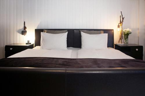 a large bed with white sheets and pillows at Ferienhaus Kollinger in Kaprun