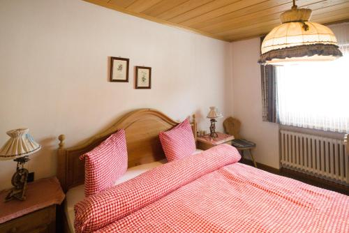 een slaapkamer met een rood bed met roze kussens bij Villa Ula Verda- Apartments Marianna in Santa Cristina in Val Gardena