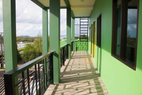 a corridor of a building with green walls and windows at N&N HOUSE Laem Hin in Ban Laem Hin