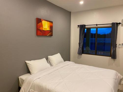 a bedroom with a white bed and a window at N&N HOUSE Laem Hin in Ban Laem Hin