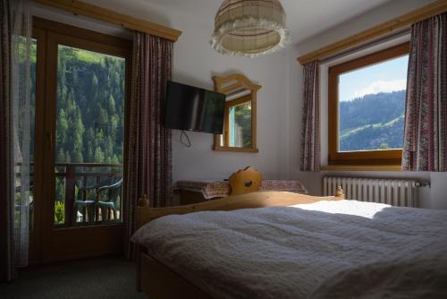 a bedroom with a bed and a large window at Villa Ula Verda- Apartments Marianna in Santa Cristina in Val Gardena