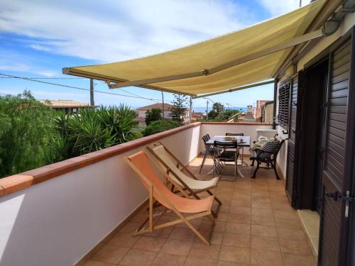 un patio con sedie e un tavolo sul balcone. di Villa Nino a Marina di Ragusa