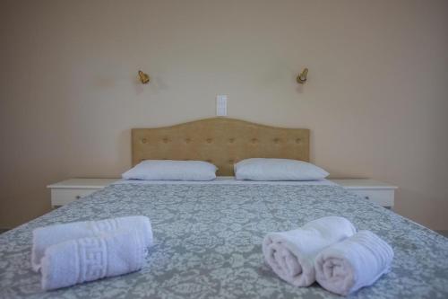 a bedroom with a bed with towels on it at eleni studios in Vlachata
