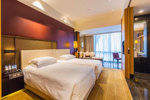 Ένα ή περισσότερα κρεβάτια σε δωμάτιο στο Hotel Kapok Shenzhen Bay