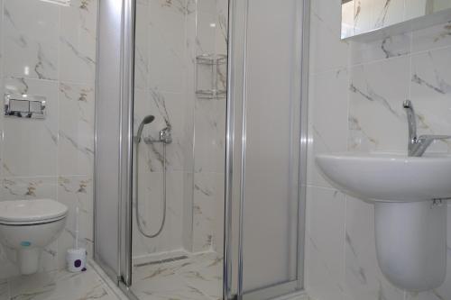 een badkamer met een douche, een toilet en een wastafel bij YILDIZ APART in Demre