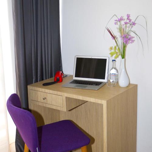 a desk with a laptop computer and a purple chair at Bourquin Hotel - Lycée Hôtelier Christian Bourquin in Argelès-sur-Mer