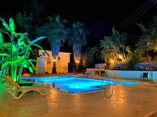 a swimming pool in a yard at night at Gera Apart Flora in Kemer