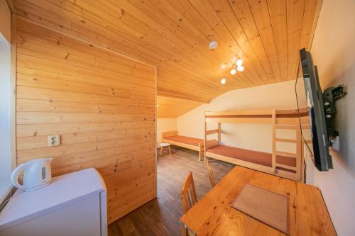 Cette petite chambre comprend une table et des lits superposés. dans l'établissement Na Rybníčku Bohutín, à Bohutín