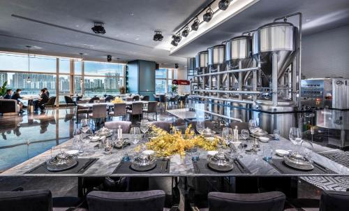 una sala da pranzo con tavolo, sedie e persone sedute ai tavoli di Guangzhou Elegant Hotel a Canton