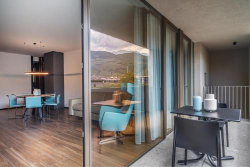 a dining room with a table and chairs and a view of a mountain at ESSENCE - Charming Suites in Riva del Garda