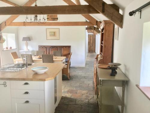 a kitchen and dining room with a table and chairs at Cuckoo Barn at Penygaer farm near the Brecon Beacons in Llandovery