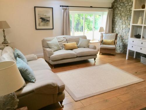 a living room with a couch and a chair at Cuckoo Barn at Penygaer farm near the Brecon Beacons in Llandovery