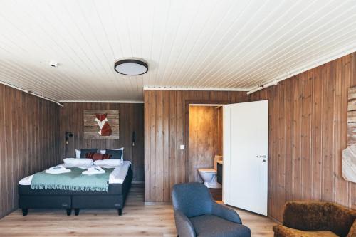 a bedroom with a bed and a chair at Skårungen - Hotel, Cabins and Camping in Kabelvåg