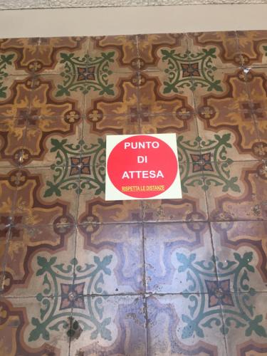 a sign on the wall of a room with tiles at Aretusa Vacanze B&B in Siracusa
