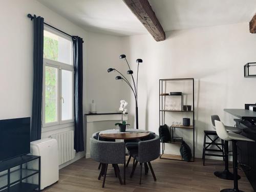 une salle à manger avec une table et des chaises et une fenêtre dans l'établissement ** La Suite Occitane ** 43m2 rénové, Gare St Roch, à Montpellier