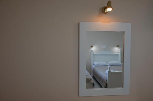 a mirror reflecting a bedroom with a bed in it at eleni studios in Vlachata