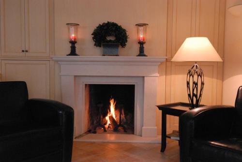 a living room with a fireplace with two candles at Strandhotel Fontana in Timmendorfer Strand
