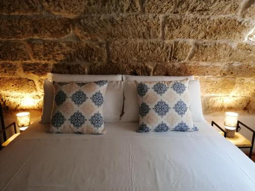 um quarto com uma cama com almofadas e uma parede de tijolos em B&B Sea Salt em Terrasini