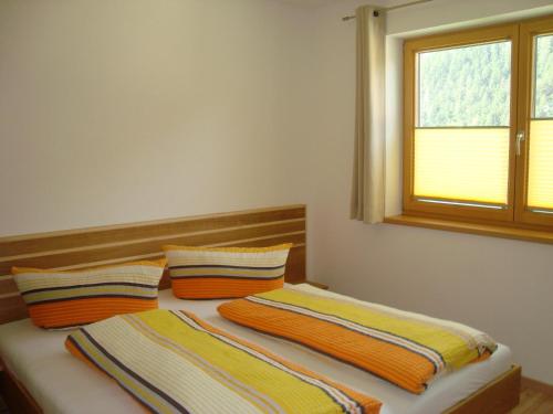 a bedroom with two beds with pillows and a window at Haus Alexander in Pfunds