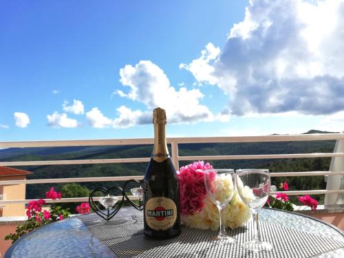 a bottle of champagne sitting on a table with glasses at Lovely apartment Branko Rabac with balcony and parking in Rabac