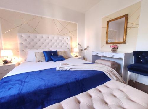 sypialnia z dużym łóżkiem z niebieską pościelą i lustrem w obiekcie Apartment Helena w Splicie