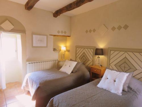 1 dormitorio con 2 camas y ventana en Les Buis de Lussan en Lussan