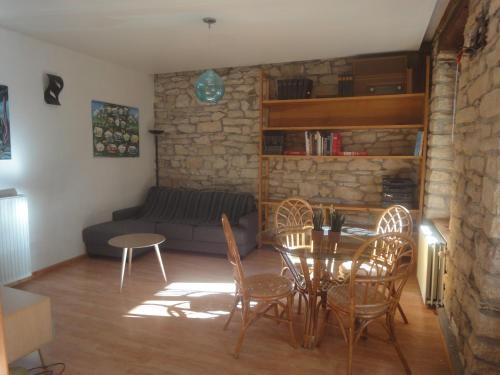 un salon avec un canapé, une table et des chaises dans l'établissement Le jardin des remparts, à Colmar