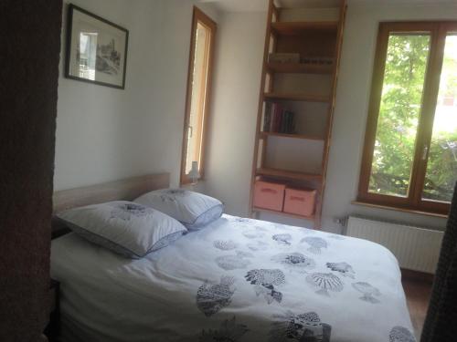 a bedroom with a bed with two pillows on it at Le jardin des remparts in Colmar