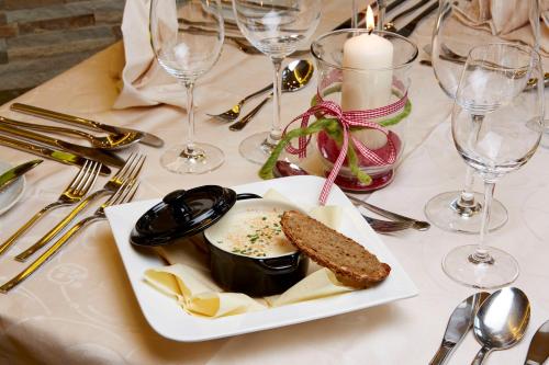a plate of food on a table with wine glasses at Wohlfühlhotel Berg Heil in Holzgau