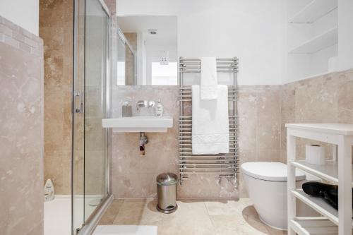 a bathroom with a shower and a toilet and a sink at The white home near Kensington high st in London