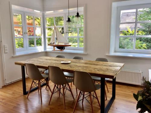 a dining room with a wooden table and a piano at Uns Landhus Tating in Tating