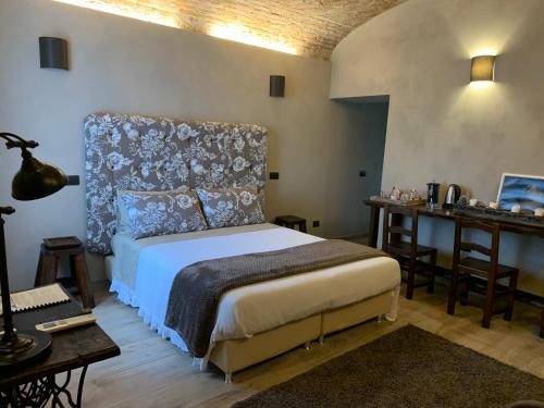 sypialnia z łóżkiem z zagłówkiem i biurkiem w obiekcie Corte degli Angeli Agriturismo w mieście Busseto